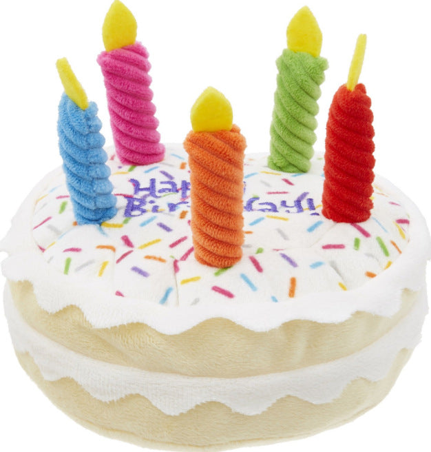 Toy birthday cake with colorful candles on a white background