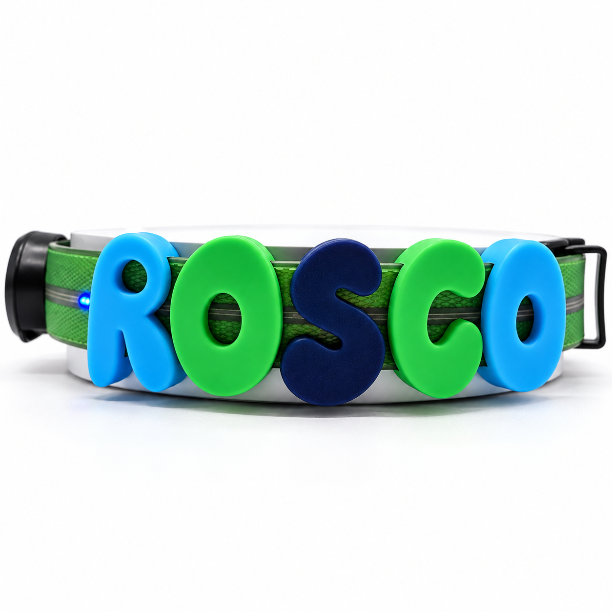 A green dog collar with large, colorful, raised letters spelling 'ROSCO' in blue and green, shown on a white background.