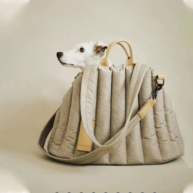 Dog peeking out from a beige pet carrier with a plain background