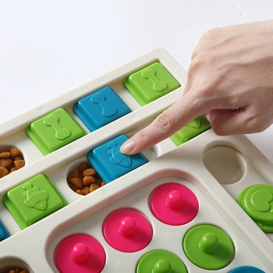 Colorful slow feeder treat puzzle being filled by a hand on a white background