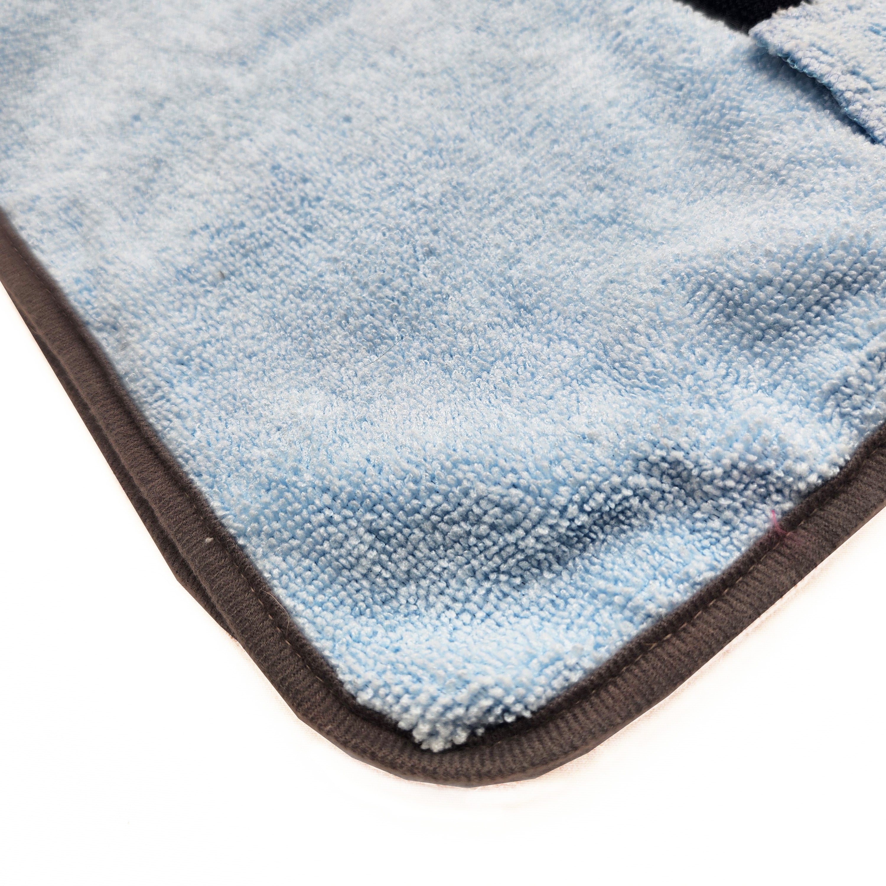 Close-up of a blue textured dog bathrobe with a white background